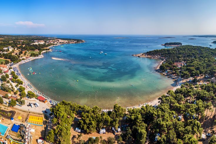 Eine Luftaufnahme einer Bucht mit türkisfarbenem Wasser.