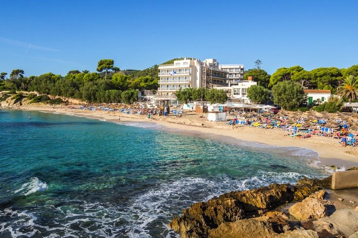 Eine Bucht mit einem Strand und türkisfarbenem Wasser.