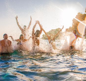 Eine Gruppe von Menschen, die im Meer planscht.