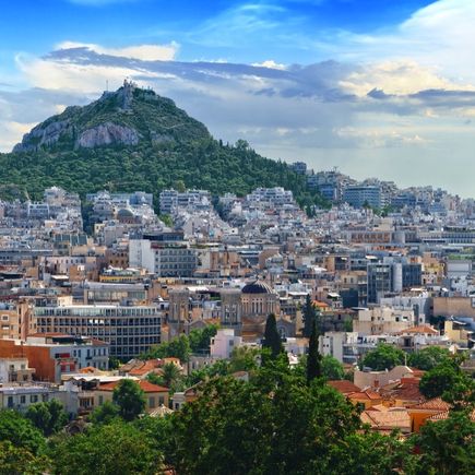Eine Stadtansicht von Athen mit Bergen und dem Meer.