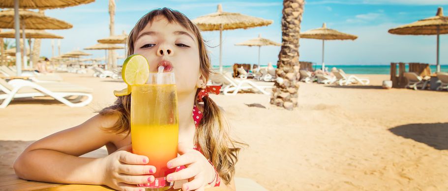 Kind mit Getränk am Strand von Tunesien