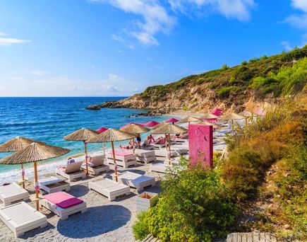 Ein Strand mit Sonnenschirmen und Liegestühlen.