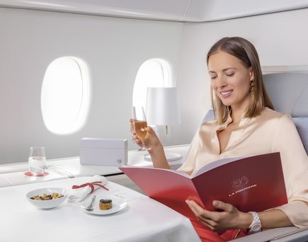 La Première, Frau mit Getränk im Flugzeug