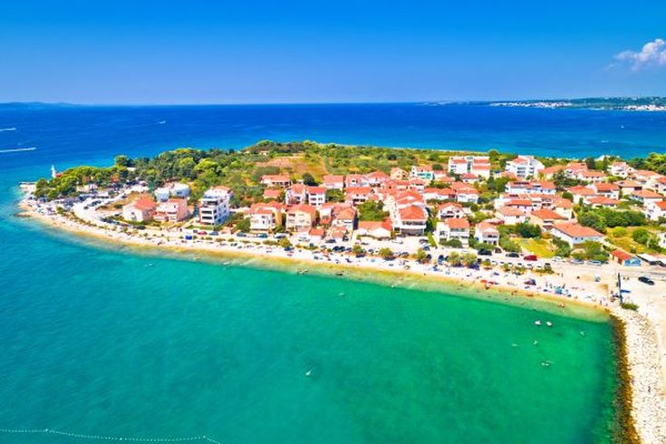 Eine Luftaufnahme einer Küstenstadt mit einer Insel und dem Meer.