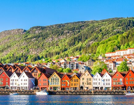 Zu sehen sind die farbenfrohen Häuser Bergens. Direkt am Wasser gelegen, jedes Haus eine andere Farbe. Kleines Bötchen liegt an Land.