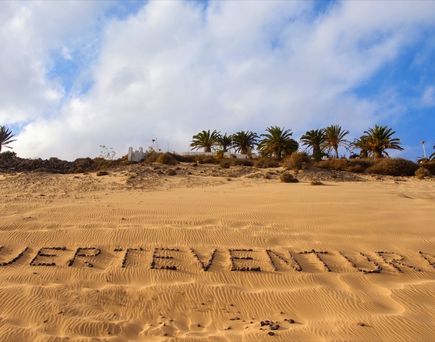 Ein Strand mit Kieselsteinen und einem Wort im Sand.