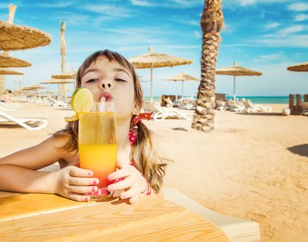 Kind mit Kindercocktail in Ägypten am Strand