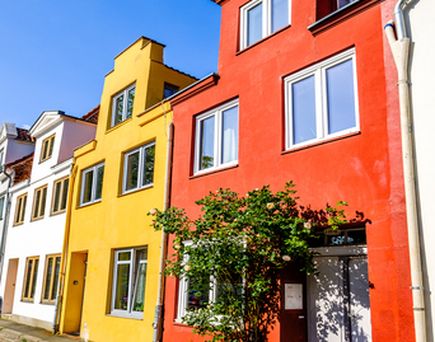 Ein buntes Haus mit roten und gelben Fassaden.