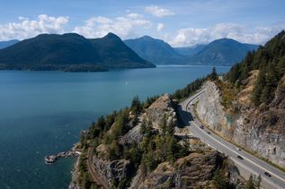 Die malerische Sea to Sky Highway (British Columbia Highway 99) schlängelt sich entlang der Küste von Vancouver, umgeben von üppigen Wäldern und majestätischen Bergen, die zum Meer abfallen.
