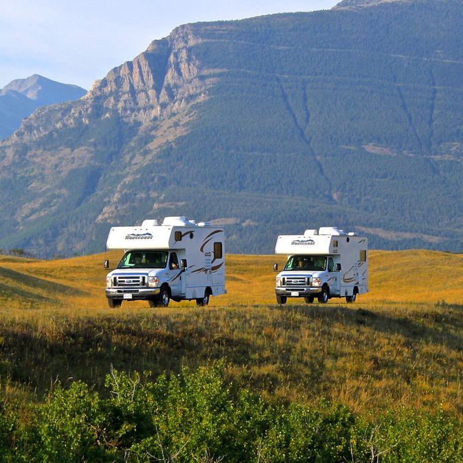 Camper fährt auf langer Straße mit Bergen in Kanada