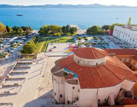 Eine Luftaufnahme der Altstadt von Zadar, Kroatien, mit roten Dächern und dem Meer.