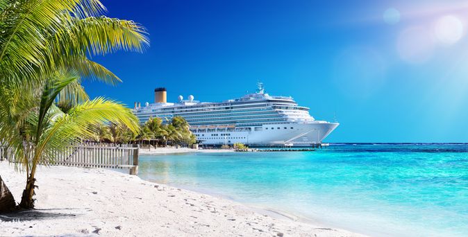 Kreuzfahrtschiff in der Karibik Links im Bild Palmen, rechts das Meer