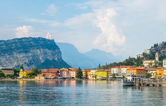 Eine Stadtansicht am See mit Gebäuden und Bergen.