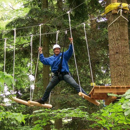Urlaub im deutschen Mittelgebirge Bayerischer Wald Kletterer im Hochseilpark
