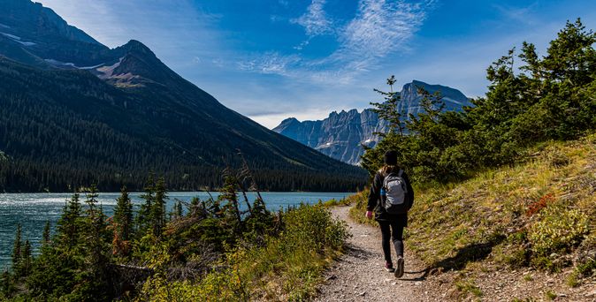 Weiblicher Wanderer am Lake Josephine auf dem Grinnell Glacier Trail, Glacier National Park, Montana, USA