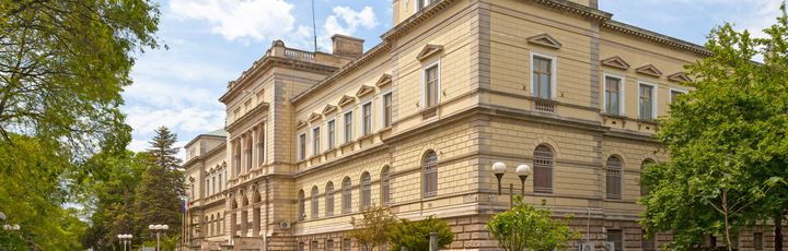 Archäologisches Museum in Varna, Blick von der Straße auf das hübsche Gebäude. Weg ist mit Gras und Bäumen geebnet.