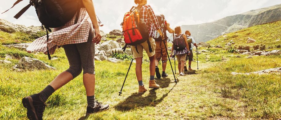 Personen wandern auf einem Weg in den Bergen.