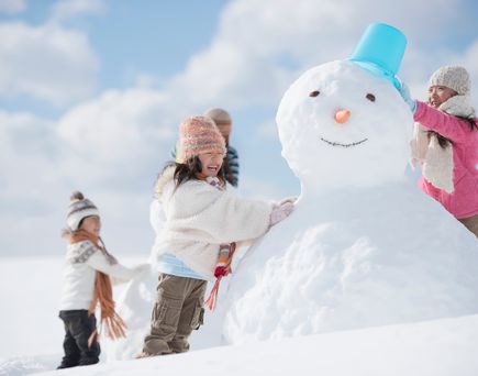 Kinder bauen Schneemann