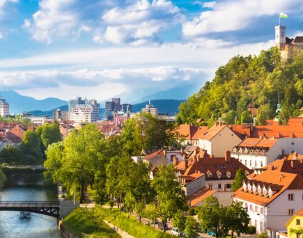 Eine Stadtansicht von Ljubljana, Slowenien, mit einem Fluss und bunten Gebäuden.