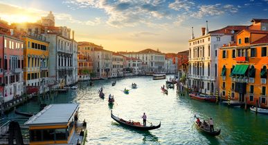 Eine Luftaufnahme von Venedig, Italien, mit Kanälen und Gebäuden bei Sonnenuntergang.