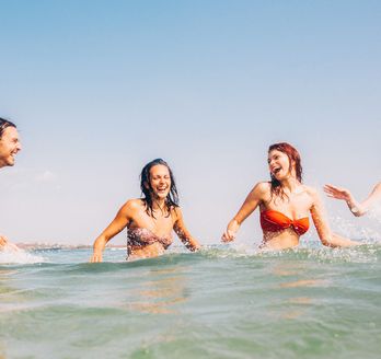 Vier Personen schwimmen im Meer.