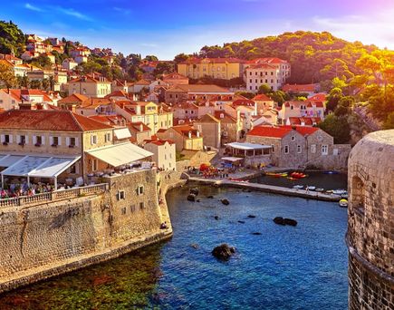 Eine Luftaufnahme von Dubrovnik mit roten Dächern und dem Meer.