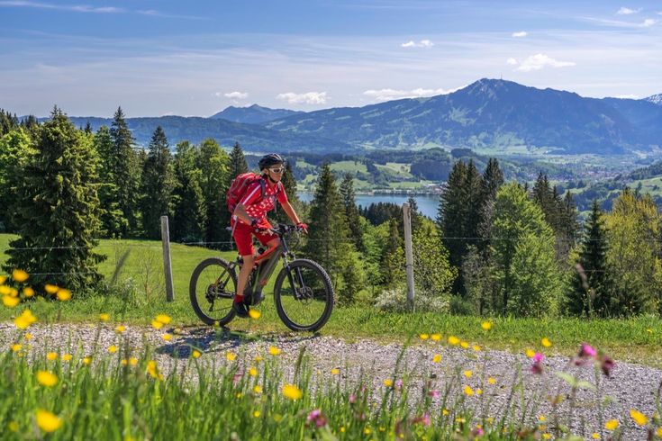 Zwei Mountainbiker fahren auf einem Weg durch eine bergige Landschaft.