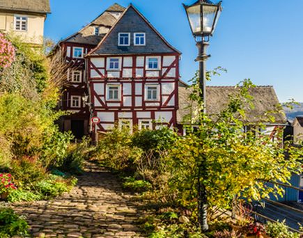 Ein charmantes Hotel oder Gasthaus auf einem Hügel, umgeben von grüner Landschaft.