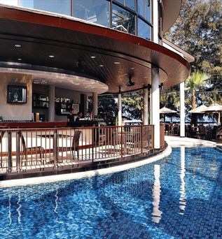 Ein Swimmingpool-Bereich mit stilvollen Sitzgelegenheiten und einem Blick auf die Anlage.