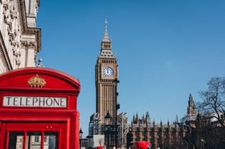 Blick auf den Big Ben in London im Vordergrund eine rote Telefonzelle