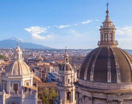 Eine Stadtansicht mit einem Dom und Gebäuden.