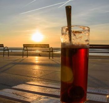 Ein Getränk am Strand bei Sonnenuntergang.