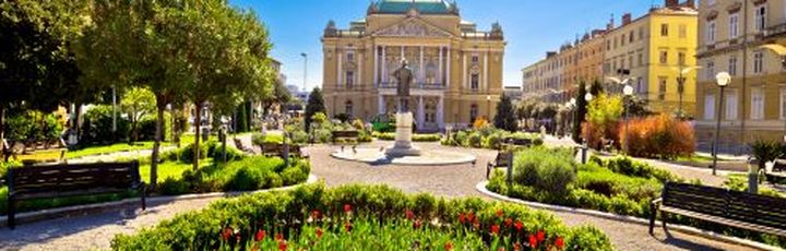 Ein Platz mit einem Brunnen und einem historischen Gebäude.