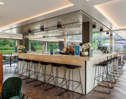 Eine moderne Bar auf einem Schiff mit einem langen Tresen und Hockern.