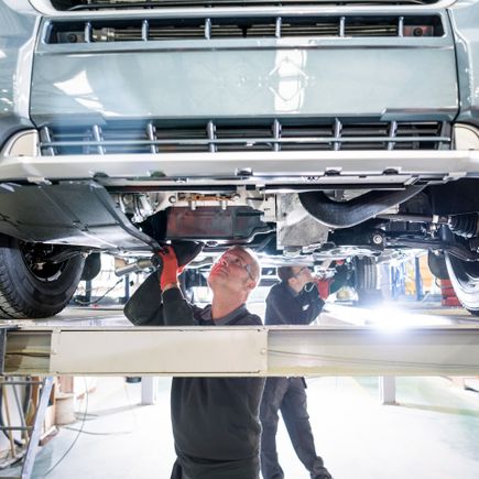 Info Camper Handbuch Wohnmobil Urlaub Arbeiter unter einem Wohnmobil