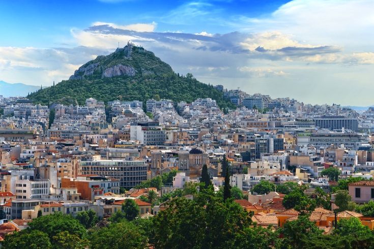 Eine Stadtansicht von Athen mit Bergen und dem Meer.