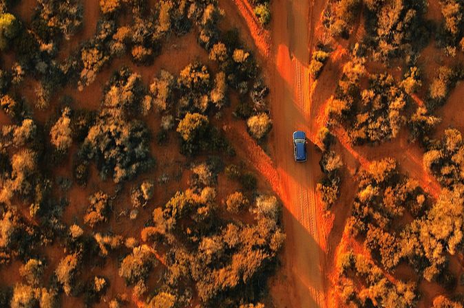 Auto fährt durch die rote Landschaft Australiens