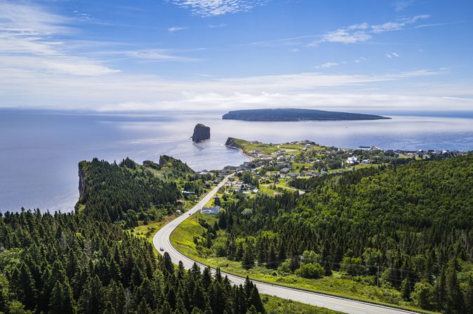 Straße entlang an Wäldern hinunter zu Percé am Meer, Gaspe Peninsula, Quebec, Canad