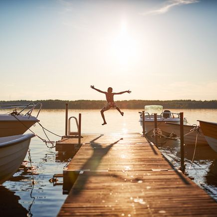 Ferienhaus Urlaub Schweden Junge springt von Steg in See