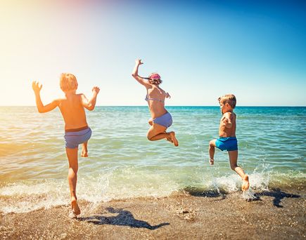 Zwei Kinder springen ins Meer.