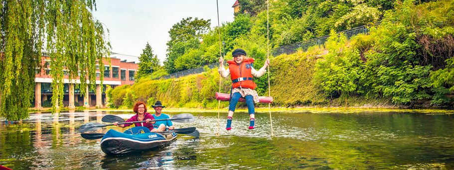 Familienurlaub Leipzig Kanufahrer und Kind auf Schaukel am Wasser