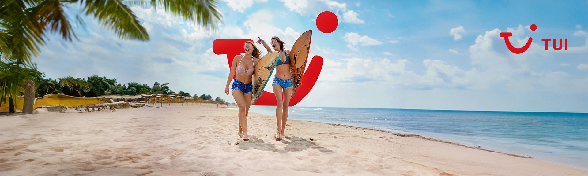Zwei Frauen am Strand mit Surfboards vor dem TUI Logo am Meer