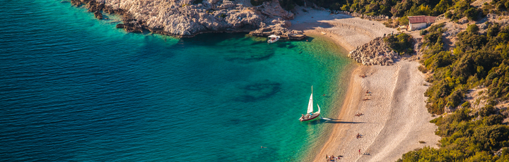 Eine Bucht mit einem Strand und türkisfarbenem Wasser.