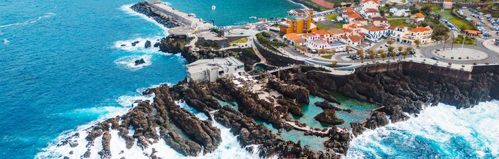 Blick auf Porto Moniz aus der Vogelperspektive. Felsige Küste umgeben vom tobenden Meer.