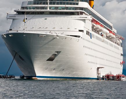 Ein Schiff liegt im Indischen Ozean, vor der Küste Madagaskars. Tenderboote sind ebenfalls zu sehen. Ein bewölkter Tag.