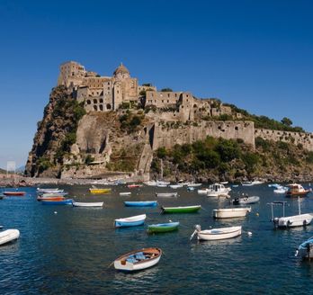 Eine Festung auf einer Insel mit Blick auf das Meer und Boote.