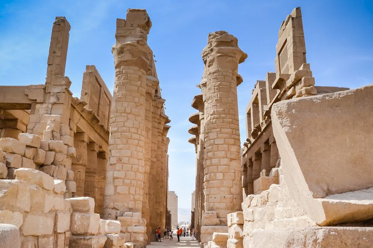 Eine archäologische Stätte in Luxor, die von einer großen Säulenreihe und alten Strukturen umgeben ist.