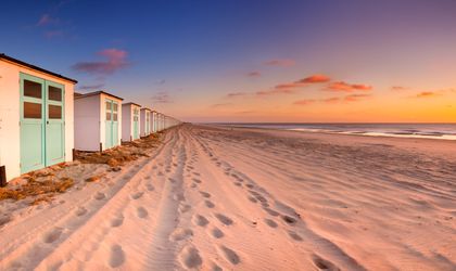Ein Strand mit kleinen Strandhütten und einem Weg.