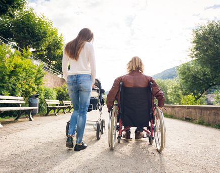 Rollstuhlfahrer Spaziergang mit Partnerin