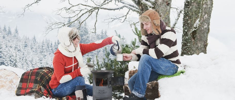 Paar trinkt Tee im Schnee